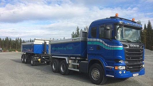 Blå lastebil med tilhenger