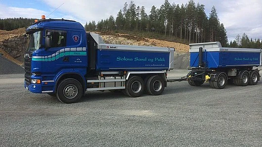 Blå lastebil med tilhenger